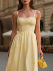 Pale yellow spaghetti strap dress by FJØRNA featuring ruched bust and flared A-line midi design.