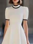 White contrast trim high neck short sleeve flared A-line mini dress by FJØRNA, featuring a stylish high neckline and flared hem.