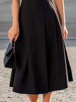 FJØRNA black sleeveless fit-and-flare midi dress with scalloped V-neck and edge detailing, perfect for elegant occasions.