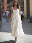 FJØRNA sleeveless square-neck button-front gathered midi dress displayed on a model in a stylish outdoor setting.