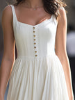FJØRNA sleeveless square-neck button-front gathered midi dress displayed on a model, showcasing its stylish design and fit.