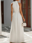 White twist halter neck maxi dress with smocked waist and flowy fabric by FJØRNA, shown on a model.
