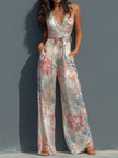 White floral satin jumpsuit by FJØRNA featuring a halter neck, wrap front, and wide-leg design.