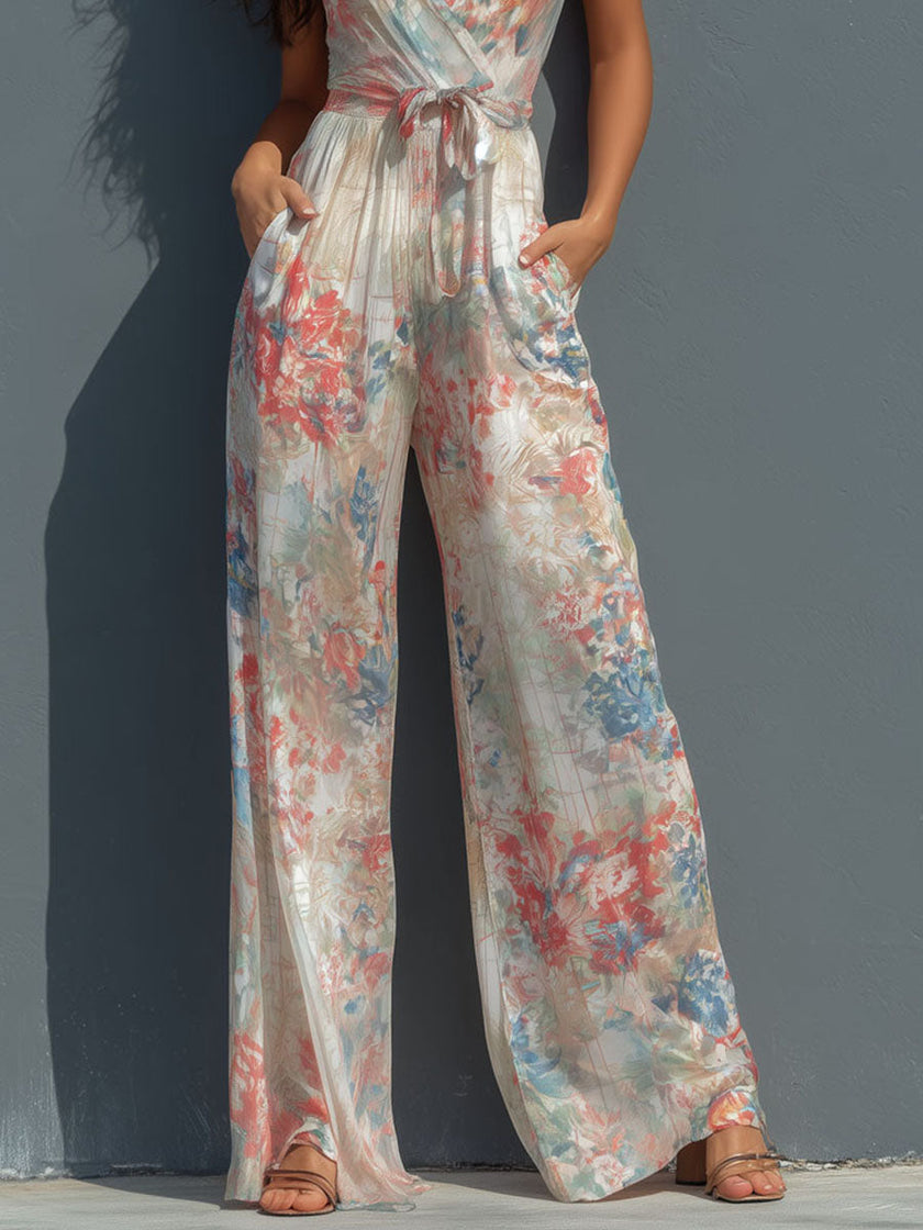White floral satin jumpsuit by FJØRNA featuring a halter neck, wrap front, and wide-leg pants.