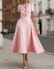 Pink satin midi dress for women with rhinestone bow detail by FJØRNA, featuring elegant and smooth fabric.