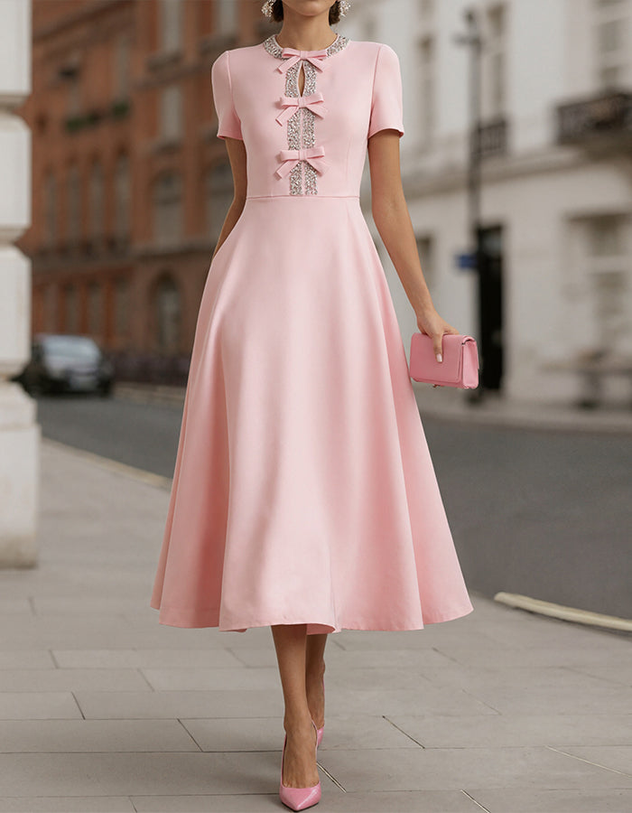 Pink satin midi dress for women with rhinestone bow detail, stylish FJØRNA fashion perfect for elegant occasions.