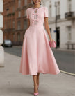 Pink satin midi dress for women with rhinestone bow detail by FJØRNA, shown on a model with elegant styling.