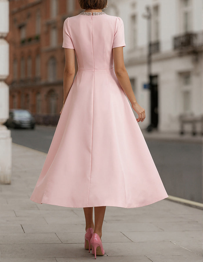 Pink satin midi dress for women with rhinestone bow detail, by FJØRNA, shown on a model.