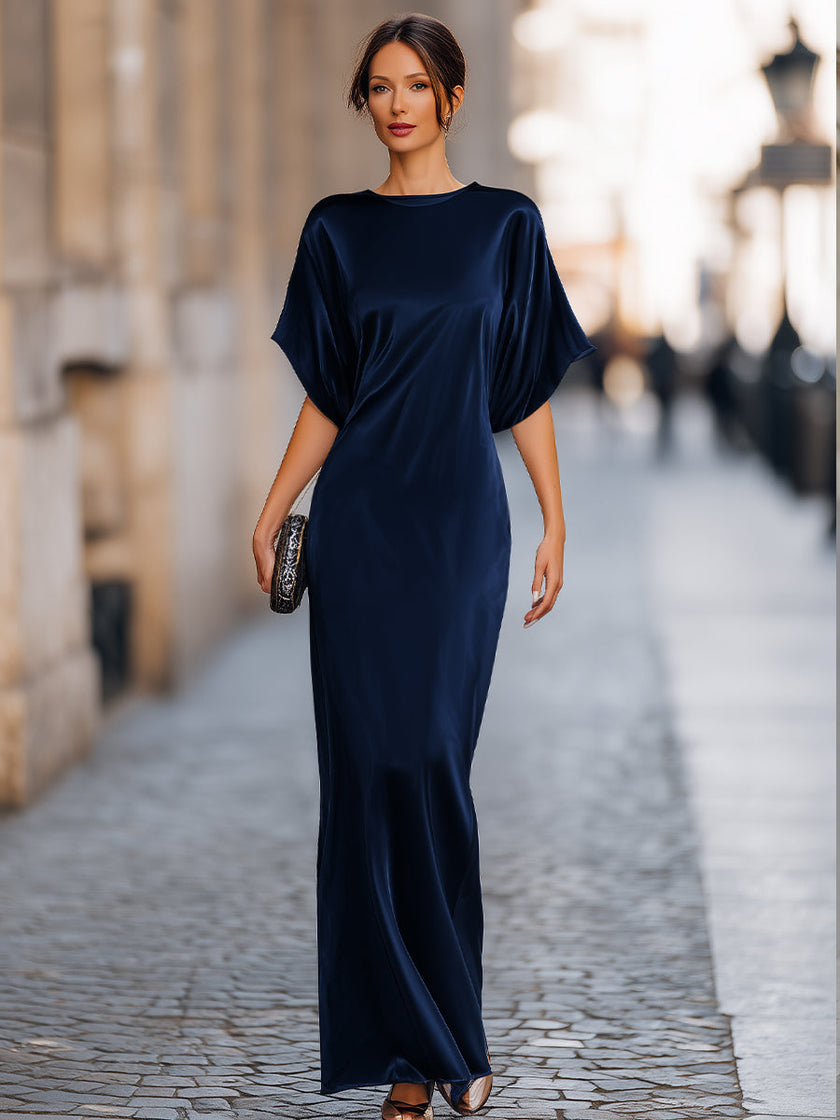FJØRNA relaxed batwing sleeve fluid column maxi dress displayed on a model, featuring a flowy silhouette and elegant design.