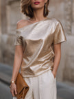 FJØRNA women's champagne one-shoulder blouse with textured fabric, relaxed fit, and asymmetric design featuring a stylish off-shoulder look.