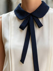 Ivory sleeveless women's blouse with Peter Pan collar and bow tie, by FJØRNA, featuring a stylish and elegant design.