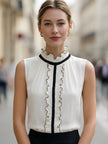 Ivory chiffon sleeveless blouse for women with ruffle high neck and black contrast trim, by FJØRNA.