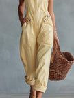 Light yellow denim jumpsuit by FJØRNA featuring a square neckline and zip-front closure, displayed on a hanger.
