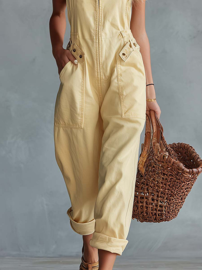 Light yellow denim jumpsuit by FJØRNA featuring a square neckline and zip-front closure, displayed on a hanger.