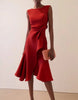 Pink FJØRNA midi dress for women with round neck, sleeveless design, ruffle details, and bow accents.