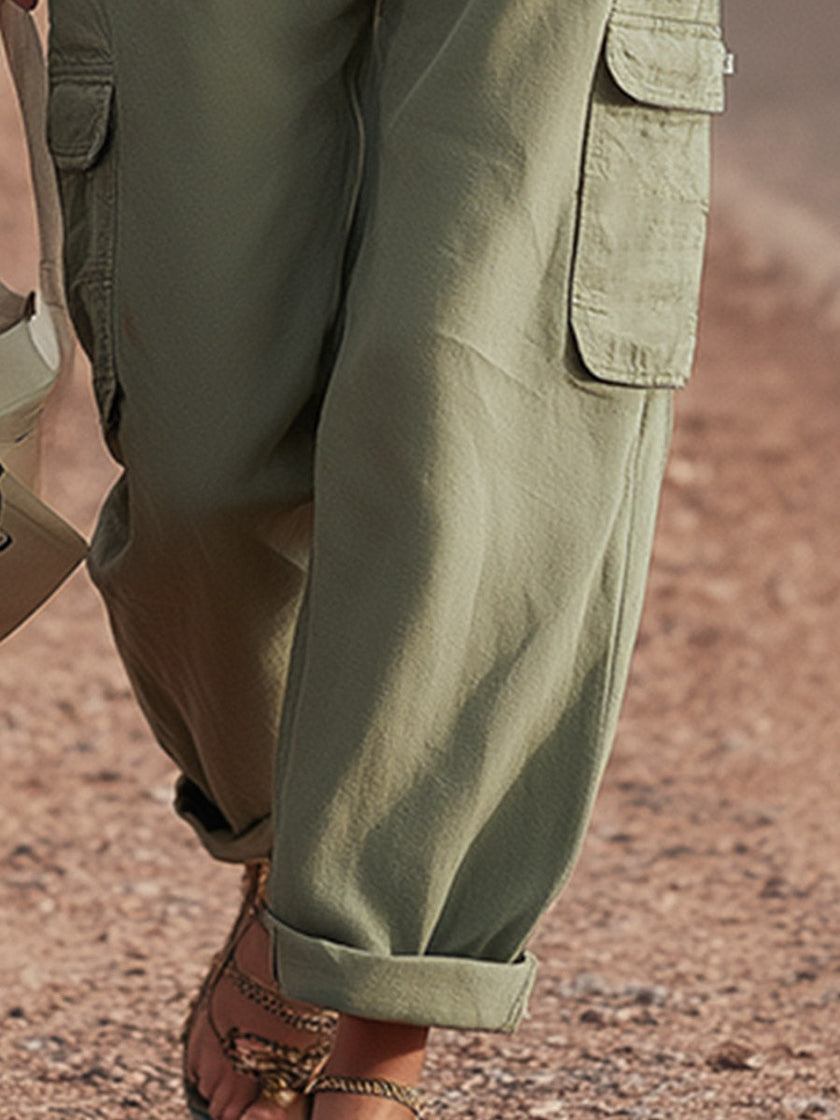 FJØRNA green women's cargo pants with multiple pockets, casual tapered trousers, made from lightweight fabric, front and side view.