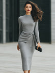 FJØRNA elegant knit midi dress with side tie detail, showcasing a stylish and comfortable black dress on a model.