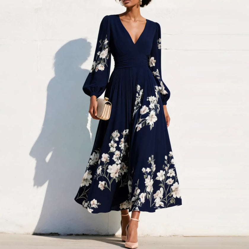 FJØRNA elegant floral print long-sleeved V-neck pleated dress displayed on a hanger, showcasing its flowing fabric and intricate floral pattern.