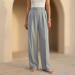 Women’s high waisted pleated wide leg trousers by FJØRNA, shown in beige fabric with a relaxed fit and wide legs.