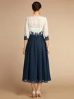 White chiffon midi dress for women with a round neck by FJØRNA, shown hanging on a clothing rack.