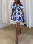 FJØRNA women's Mediterranean style printed tie mini dress with floral pattern and lightweight fabric, perfect for summer wear.