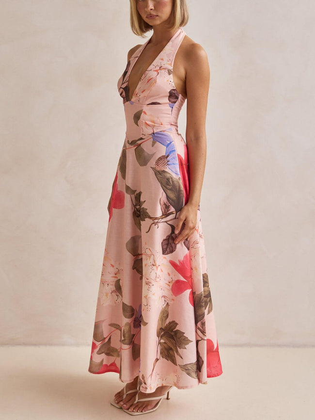 FJØRNA floral print halter backless tie-up women's maxi dress hanging on a display mannequin.