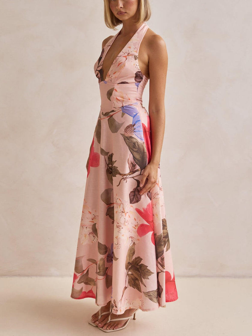 FJØRNA floral print halter backless tie-up women's maxi dress hanging on a display mannequin.