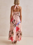 Floral print halter backless tie-up maxi dress for women by FJØRNA, featuring a flowy design and vibrant floral pattern.