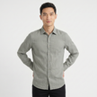Men's FJØRNA long sleeve linen button-down shirt shown on a hanger, lightweight breathable fabric, neutral color, casual style.