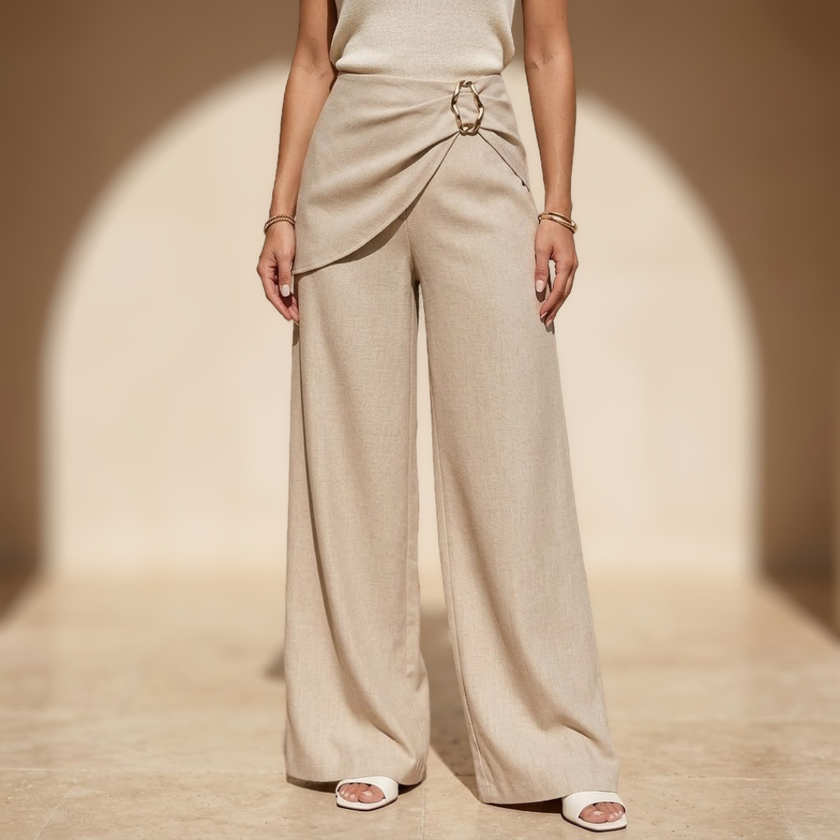 Women’s beige asymmetric waist trousers with metal buckle from FJØRNA, featuring a stylish tailored fit and modern design.