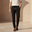 Men's FJØRNA trousers featuring a classic fit, dark fabric, and front pockets, styled for casual or business wear.