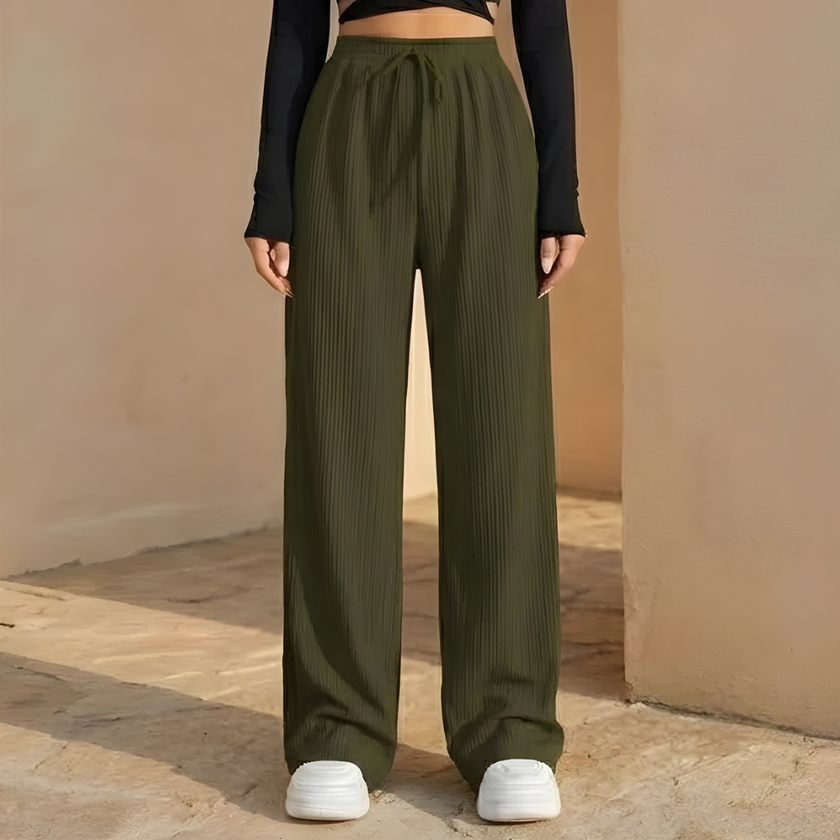 FJØRNA women's wide leg trousers with elastic waist and pleated design, shown in a natural fabric and relaxed fit.