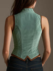 FJØRNA sage velvet slim-fit waistcoat tank top with leather trim, showcasing its elegant design and textured fabric.