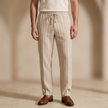 Men's linen trousers by FJØRNA featuring relaxed fit, drawstring waist, and lightweight breathable fabric.