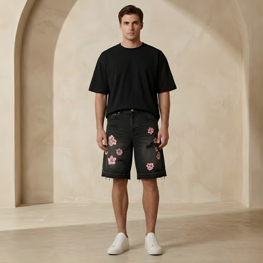 Men's denim shorts by FJØRNA with floral pattern, casual style, and distressed details.
