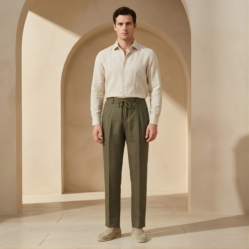 Men's linen trousers by FJØRNA with drawstring waist and pleated design, shown in a relaxed fit style.