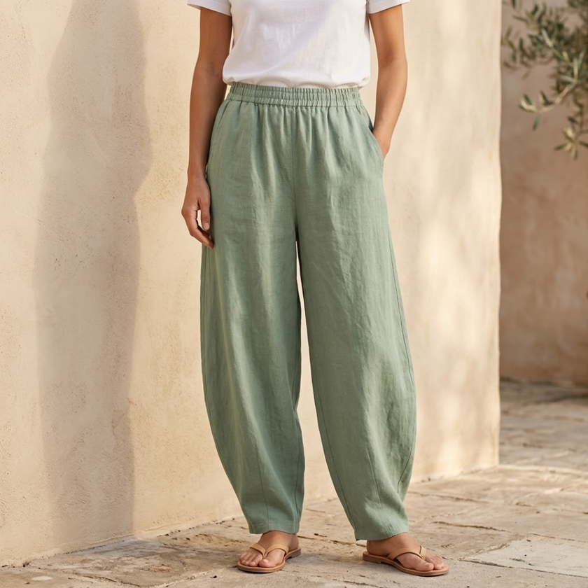 FJØRNA women's cotton linen wide-leg trousers with relaxed fit, light fabric and natural beige color, shown flat.