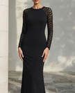 FJØRNA sheer sleeve sculpted floor-length evening dress with elegant long sleeves and fitted silhouette for formal occasions.