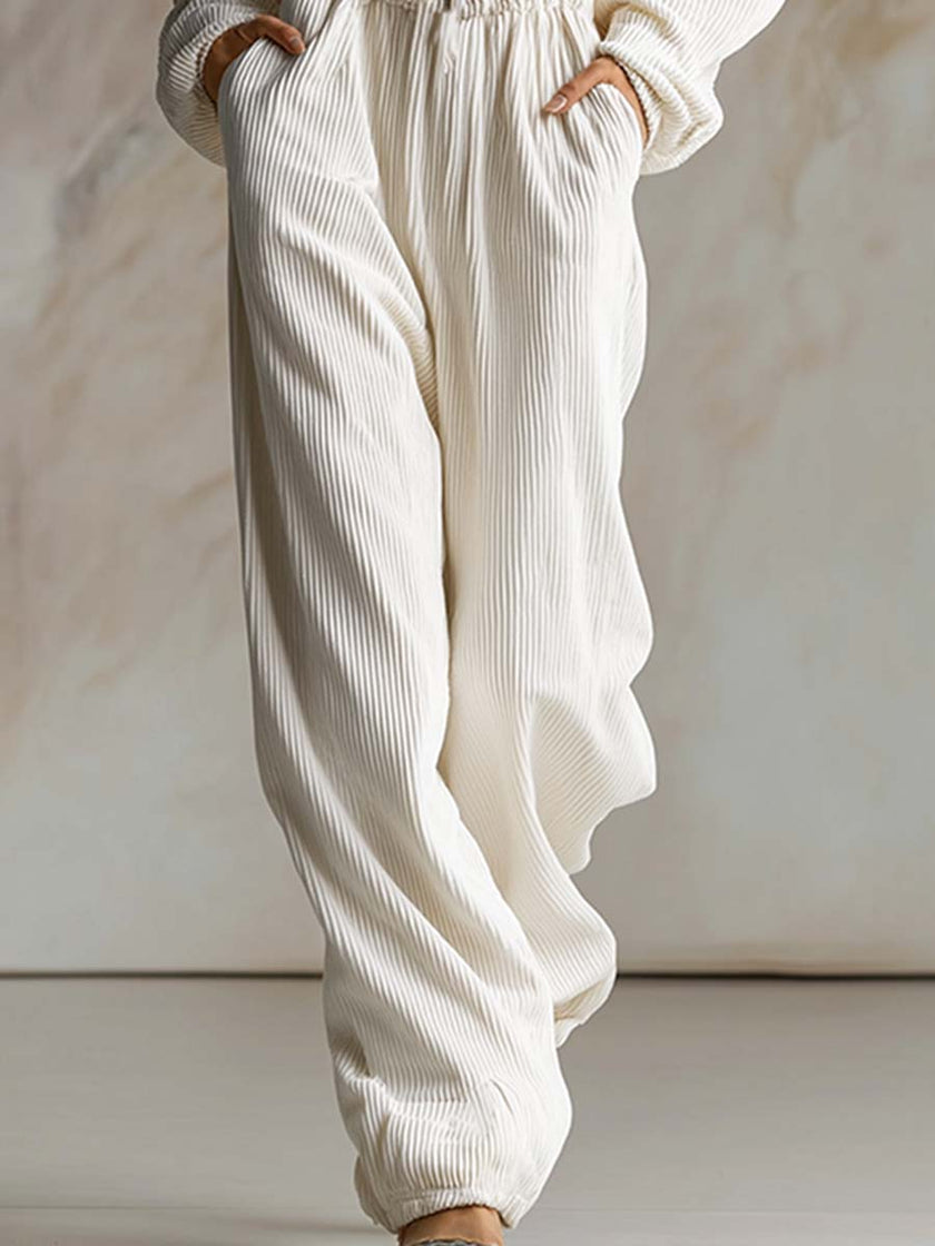 White corduroy hooded zip-front jumpsuit by FJØRNA featuring long sleeves and a casual, cozy style.