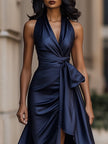 Elegant midnight satin halter gown with ruffle details by FJØRNA, showcased on a model in a formal setting.