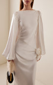 FJØRNA Vivir balloon-sleeve rose-detailed hammered satin maxi dress, elegant design with flowy silhouette and floral accents.