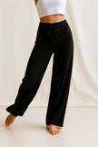 FJØRNA women's cashmere joggers pants displayed on a hanger, showcasing their soft fabric and relaxed fit for comfortable style.