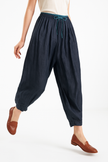 FJØRNA women's tapered linen trousers displayed flat, showcasing lightweight, breathable fabric and modern relaxed fit.