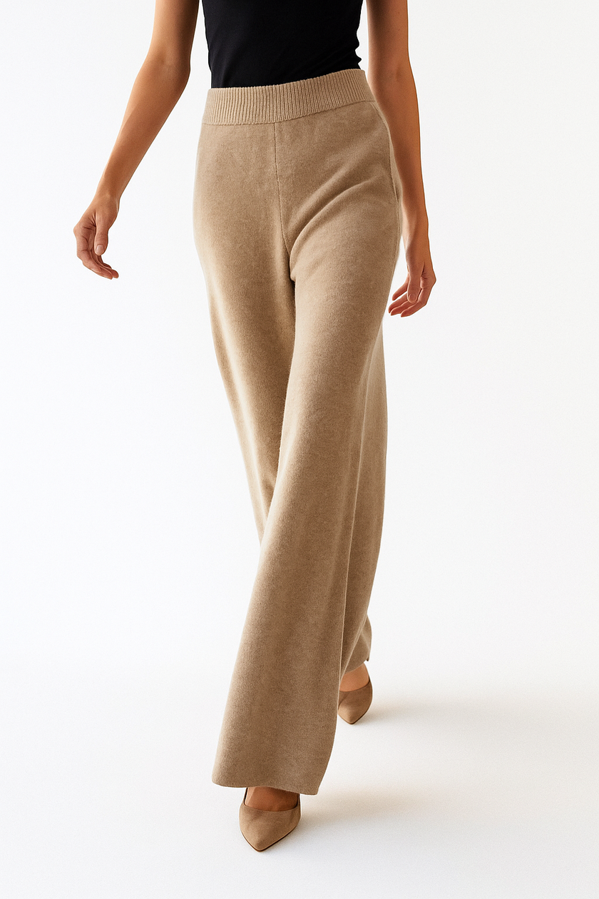 FJØRNA women's joggers pants in cozy cashmere, featuring a relaxed fit and elegant design, shown hanging on a rack.