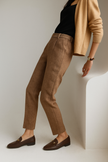 FJØRNA wool blend women’s high waist tapered trousers with tailored fit, shown in a neutral color on a model.