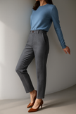 Women’s gray wool blend tapered high waist trousers by FJØRNA, shown worn with a relaxed fit and tailored design.