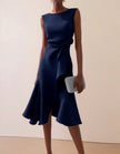 Pink FJØRNA midi dress for women with round neck, sleeveless design, ruffle details, and bow accents.