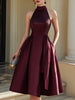 FJØRNA halter neck pleated midi dress featuring a flowy, elegant design with a fitted waist and soft pleats.
