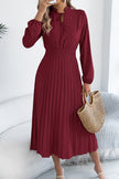 FJØRNA solid color long-sleeved fitted waist pleated midi dress displayed on a mannequin. Elegant and stylish design.