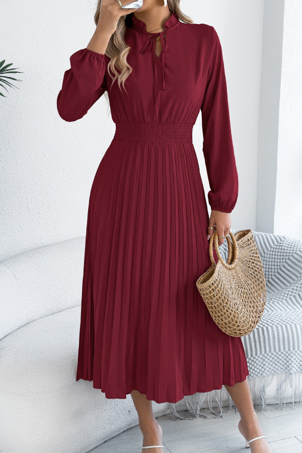 FJØRNA solid color long-sleeved fitted waist pleated midi dress displayed on a mannequin. Elegant and stylish design.